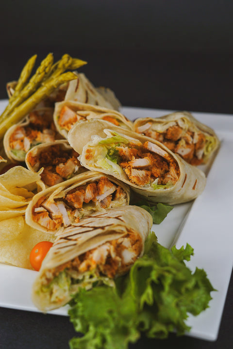 Grilled Chicken Caesar Wraps with Romaine lettuce, Parmesan cheese, and Caesar dressing